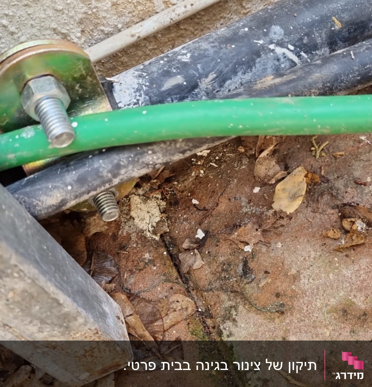 צינור ירוק וברגים על רצפה מלוכלכת